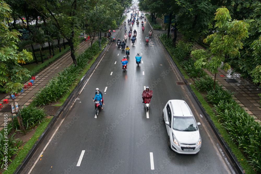 HO CHI MINH, VIETNAM - MAY 13 2017: Undefined motorcycle traffic in rain. Is located in the South of Vietnam, is the country's largest city HO CHI MINH, VIETNAM - MAY 13 2017: Undefined motorcycle traffic in rain. Is located in the South of Vietnam, is the country's largest city