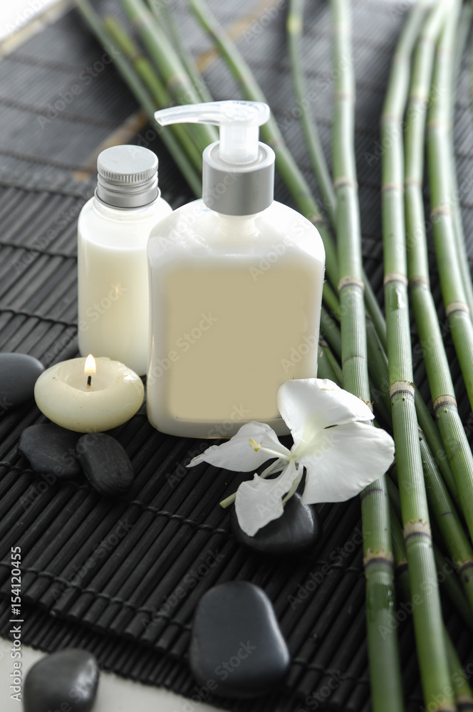 Spa setting with candle ,stones ,grove on mat Spa setting with candle ,stones ,grove on mat