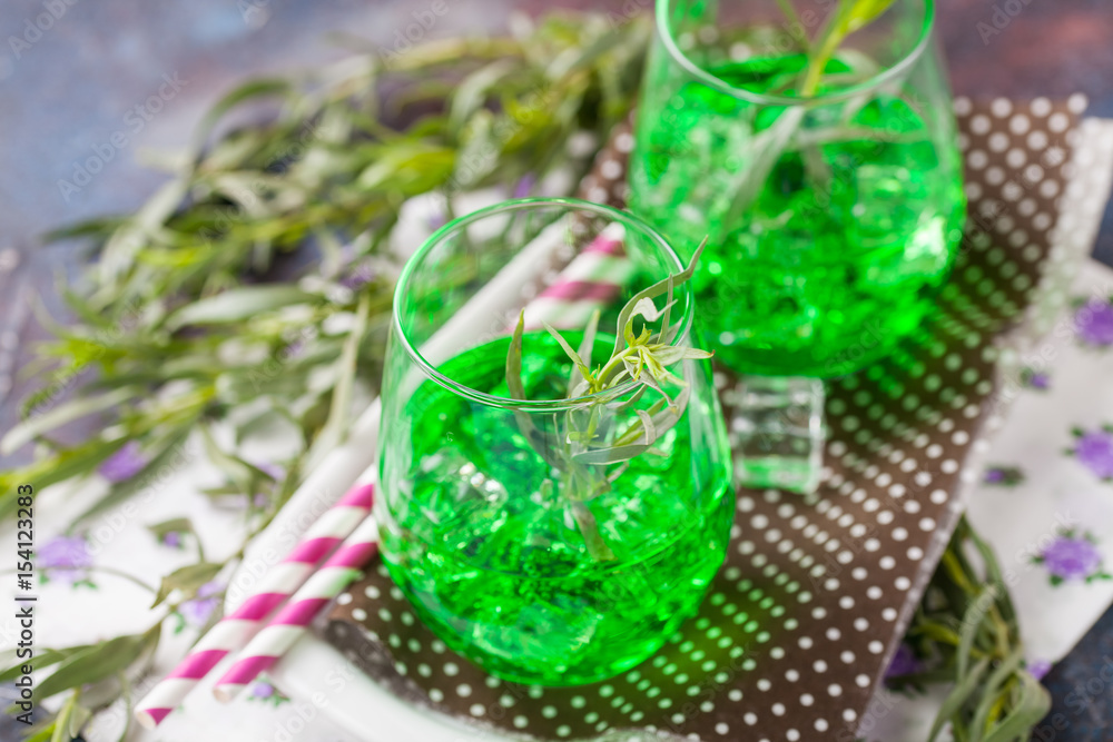 Drink from an estragon with ice in a glass on a table. Selective focus. Copy space Drink from an estragon with ice in a glass on a table. Selective focus. Copy space
