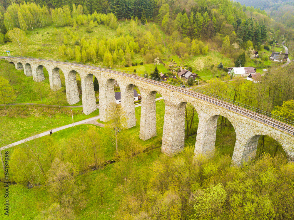 Aerial view of old railway stone viaduct. Tourist attraction in Krystofovo Udoli (Christofsgrund), Novina, Czech republic. Famous historical viaduct in Liberecky kraj, European union.