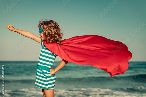 Superhero child on the beach. Summer vacation concept photo