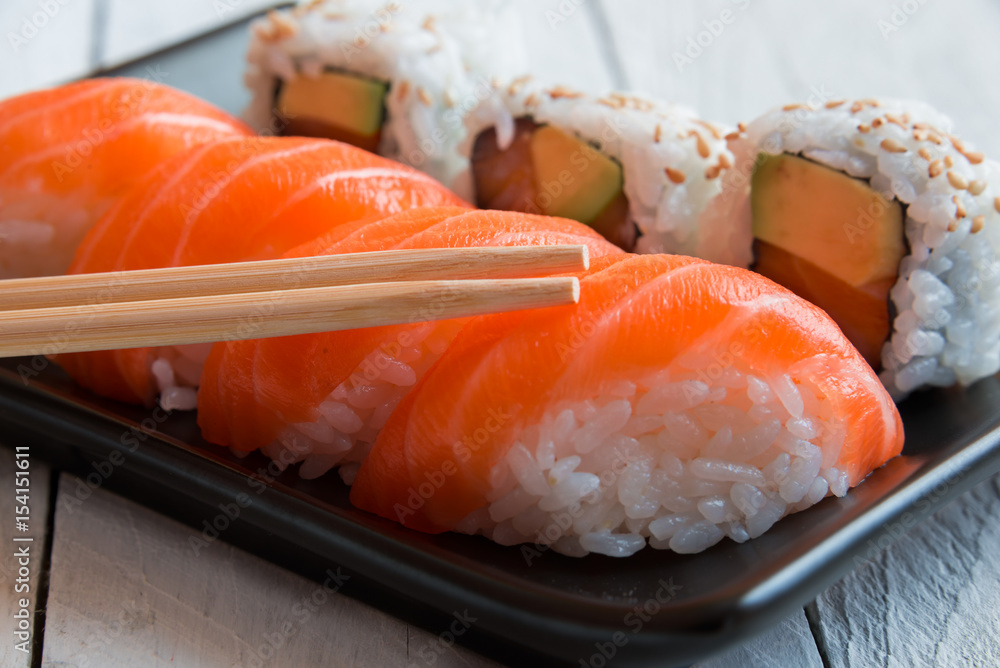 Salmon sushi and roll sushi with chopstisks Salmon sushi and roll sushi with chopstisks