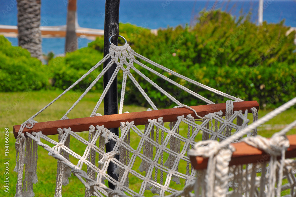 empty hammock in a green bright garden overlooking the sea empty hammock in a green bright garden overlooking the sea