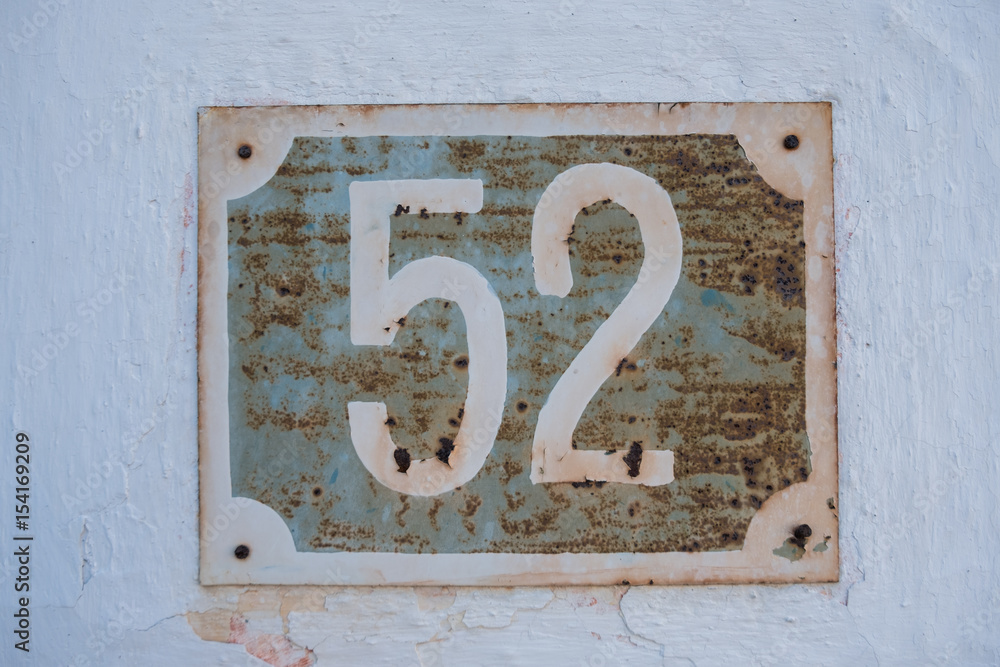 Very old rusty house number 52 plate on cracked white facade Stock ...