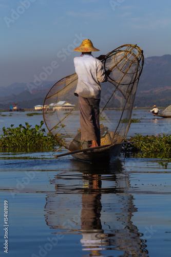 Traditional burmese fisherman on his boat at Inle lake