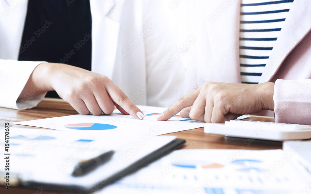 Business Women working together on data paper at a modern office Business Women working together on data paper at a modern office