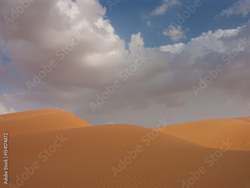 wavy dunes and cloudy skies