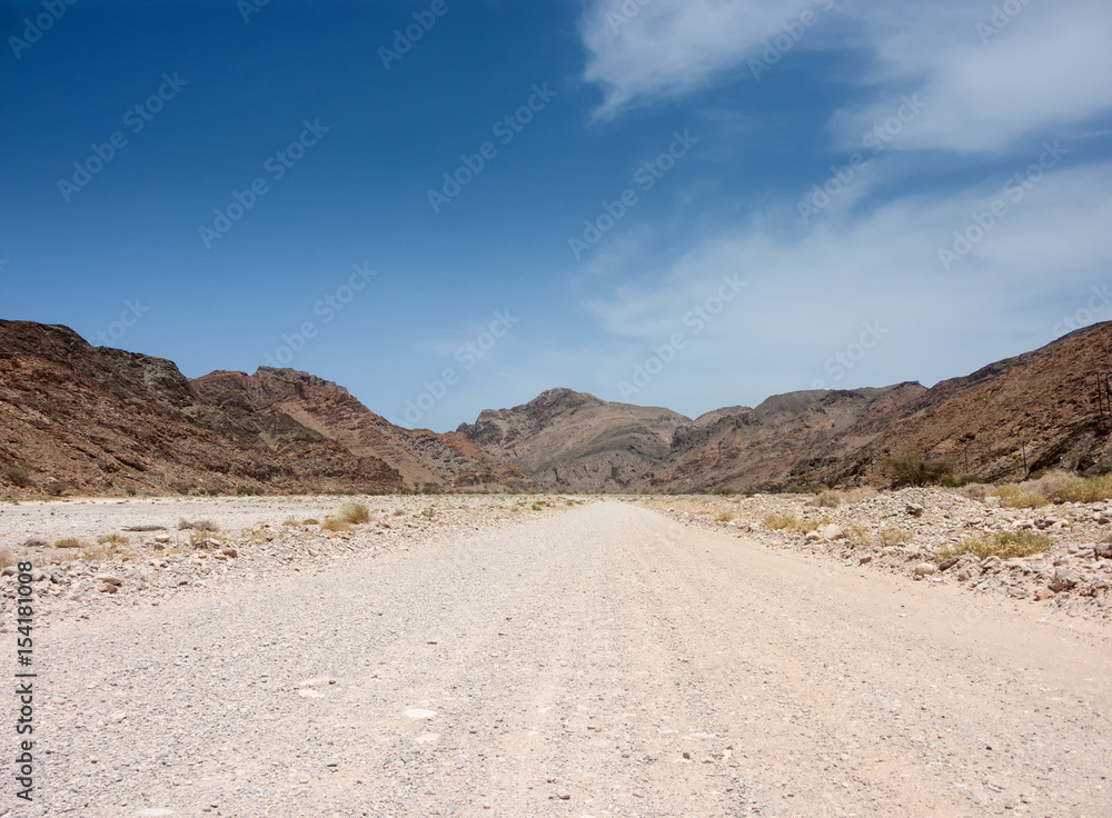 wadi road towards hills in oman