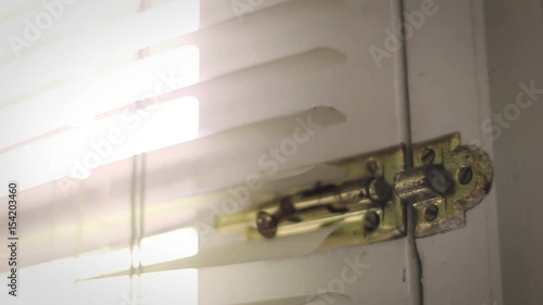 Man locks and unlcocks old rusty deadbolt in his garage or backdoor in evening