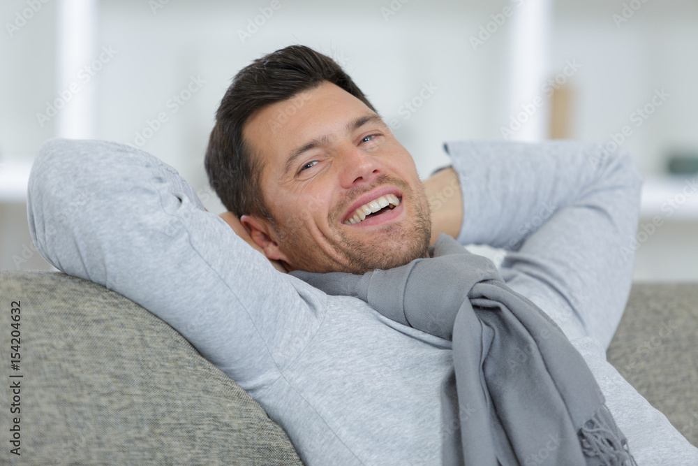 man smiling on sofa man smiling on sofa