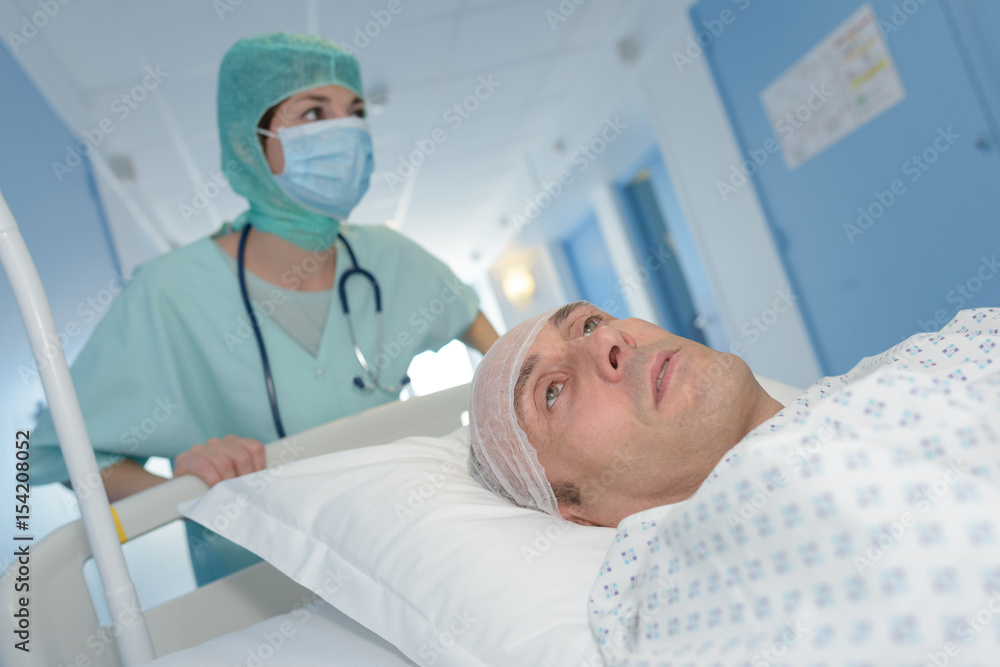 nurse carrying male patient on stretcher after brain surgery nurse carrying male patient on stretcher after brain surgery