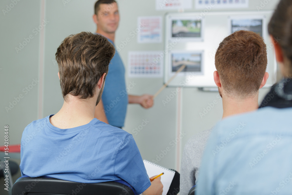 Obraz premium Rear view of students in highway code lesson