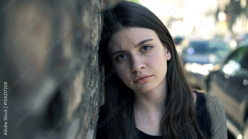 Portrait of sad, unhappy girl standing by brick wall in city
Portrait of sad, unhappy girl standing by brick wall in city