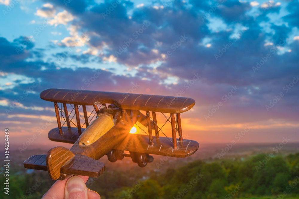 The hand launch toy plane on the background of a sunrise