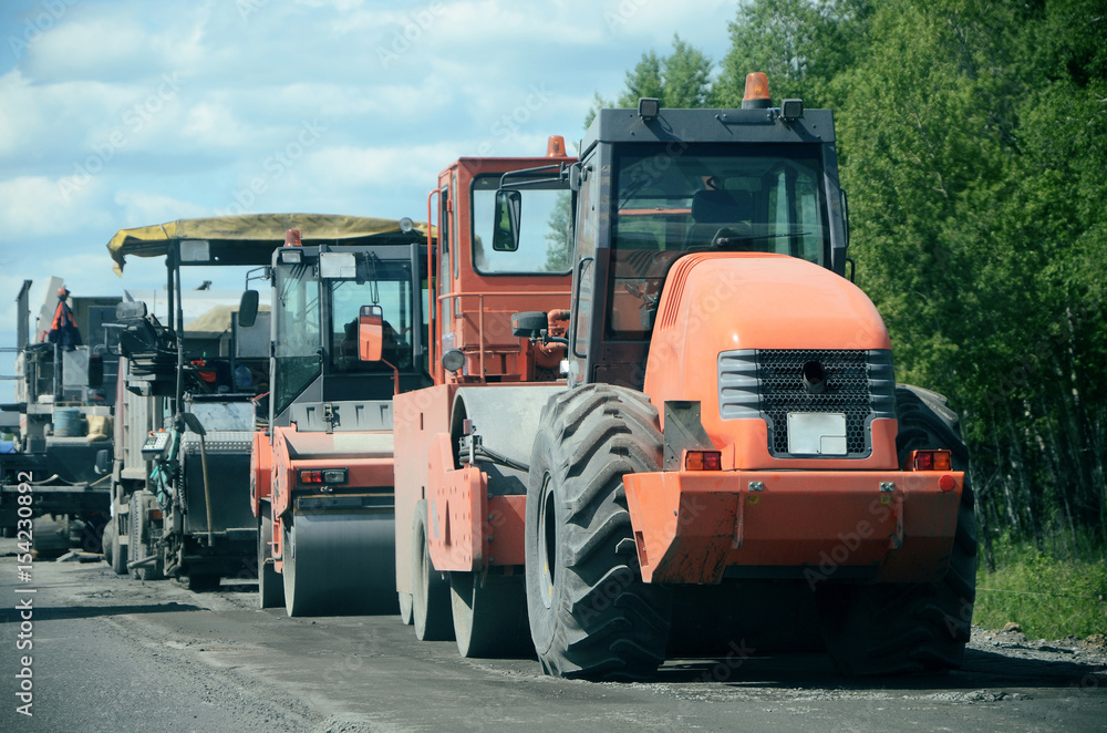 Tractor, roller , truck on the road repair site. Road construction equipment. Road repair concept. Tractor, roller , truck on the road repair site. Road construction equipment. Road repair concept.