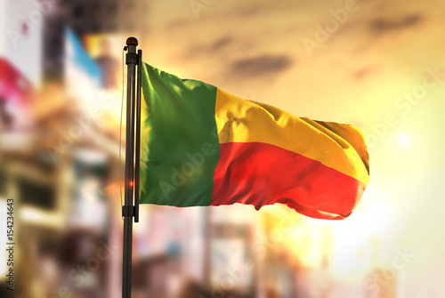 Benin Flag Against City Blurred Background At Sunrise Backlight photo