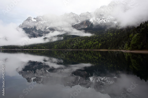 Berg spiegelt sich im See mit Frühnebel 