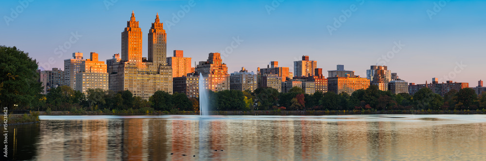 Panoramic view of Central Park West high-rise buildings and the Jacqueline Kennedy Onassis Reservoir at dawn. Upper West Side, Manhattan, New York City Panoramic view of Central Park West high-rise buildings and the Jacqueline Kennedy Onassis Reservoir at dawn. Upper West Side, Manhattan, New York City