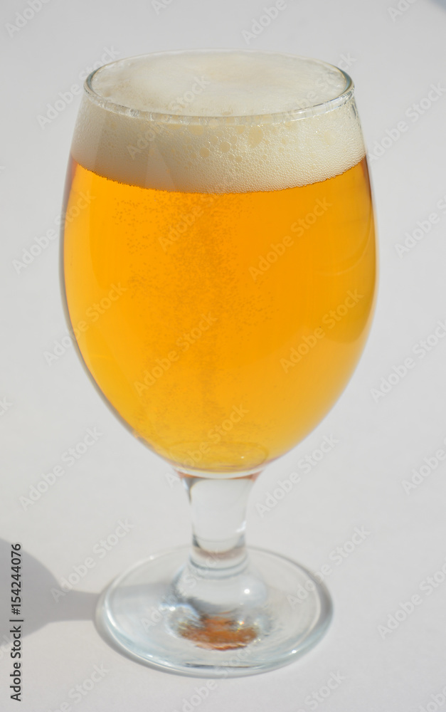 a glass of light beer on black glossy background a glass of light beer on black glossy background