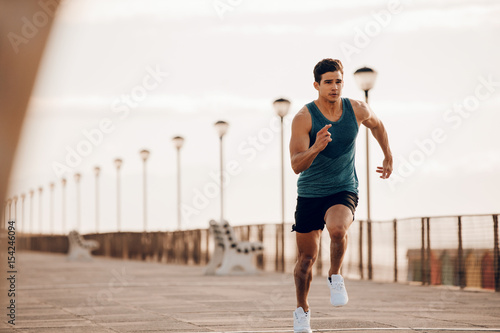 Male runner sprinting outdoors in morning