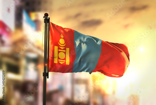 Mongolia Flag Against City Blurred Background At Sunrise Backlight