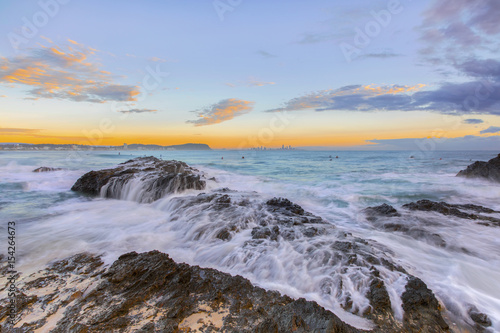 Ocean tide cascading over the rocks during sunrise at Currumbin Rock  Gold Coast