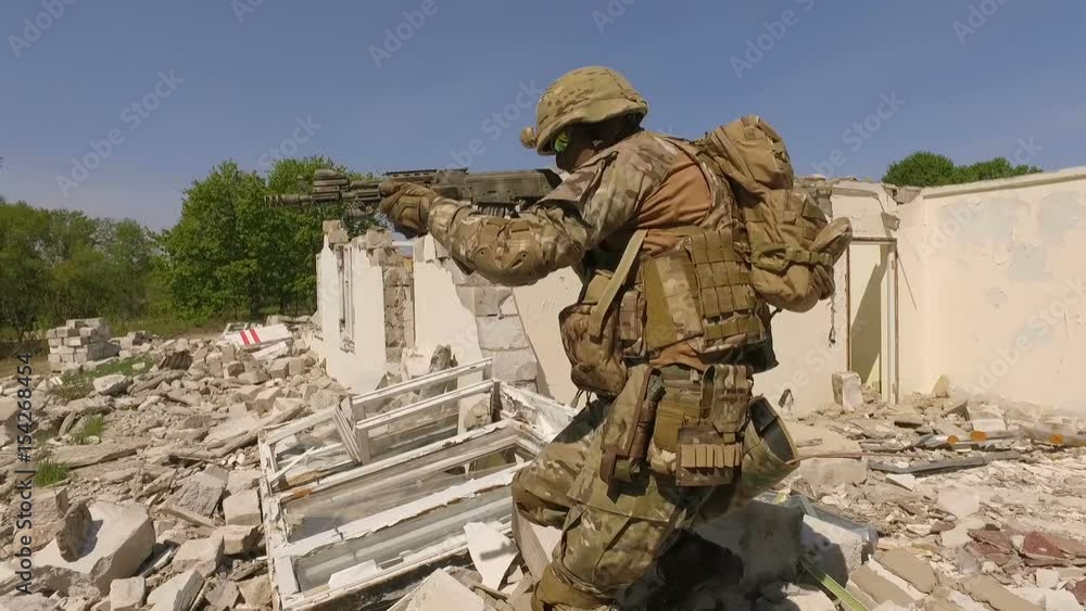 A soldier in equipment and with arms inspects a ruined house outside the city. Staging video. Kiev, Ukraine A soldier in equipment and with arms inspects a ruined house outside the city. Staging video. Kiev, Ukraine
