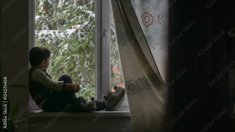 boy sits and stares out the window boy sits and stares out the window