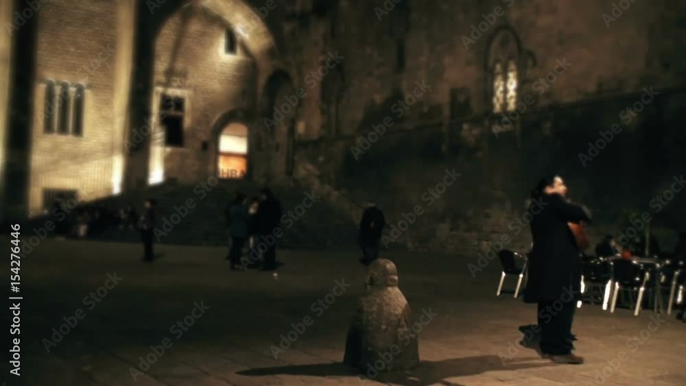 Street musician plays guitar on street at night Street musician plays guitar on street at night