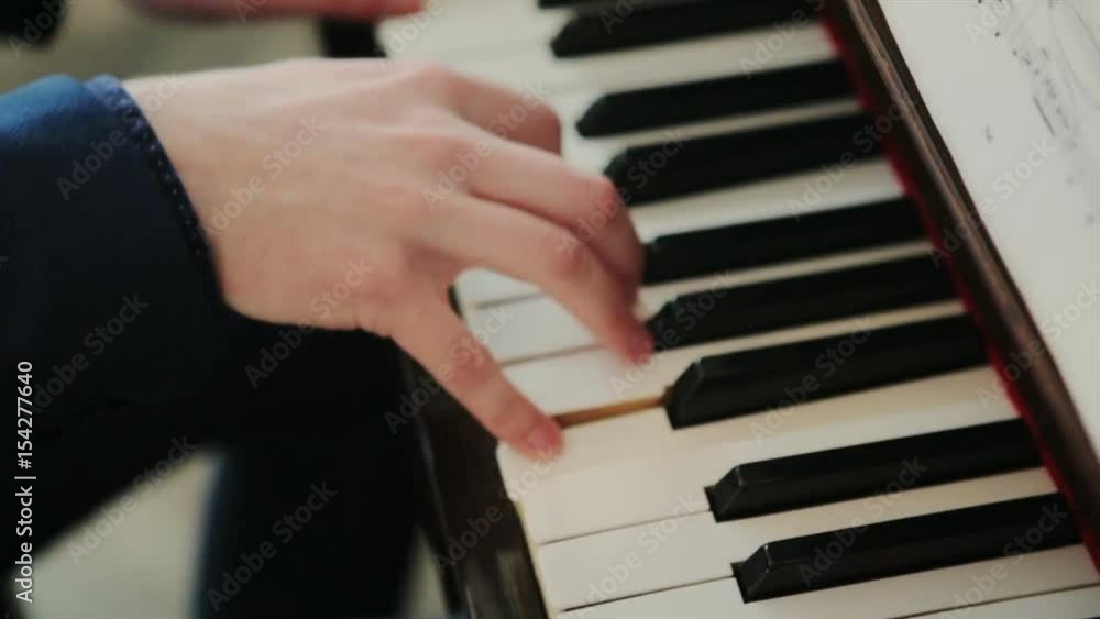 pianist in blue suit plays rapidly on the piano. top view, close up, slow motion. pianist in blue suit plays rapidly on the piano. top view, close up, slow motion.