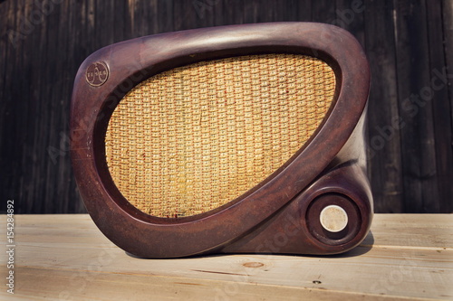 Old brown vintage bakelite Tesla radio on wooden background photo