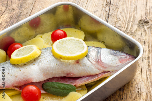 Fish with lemon potatoes and tomatoes ready for the oven