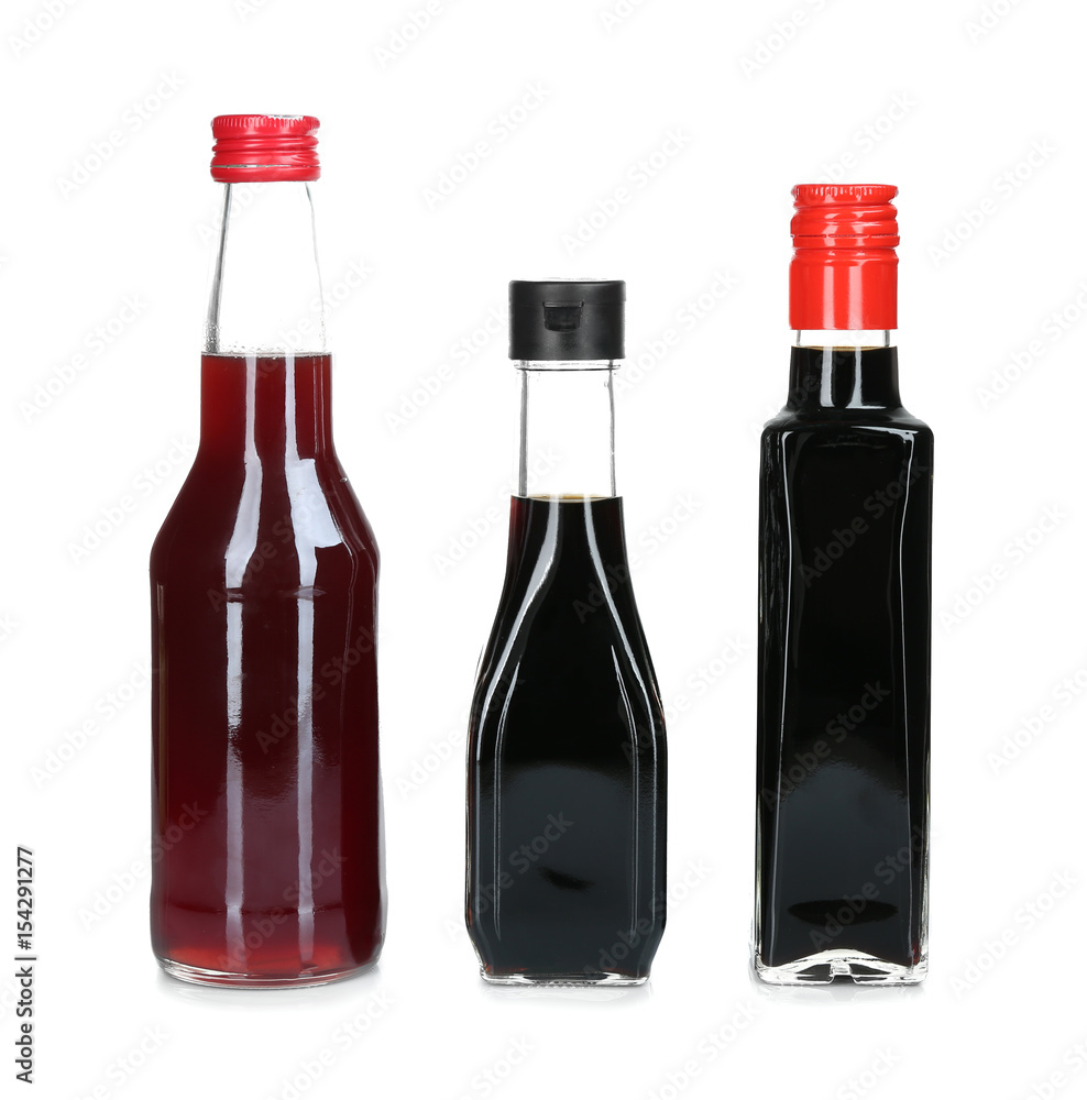 Glass bottles of liquid sauces isolated on white Glass bottles of liquid sauces isolated on white