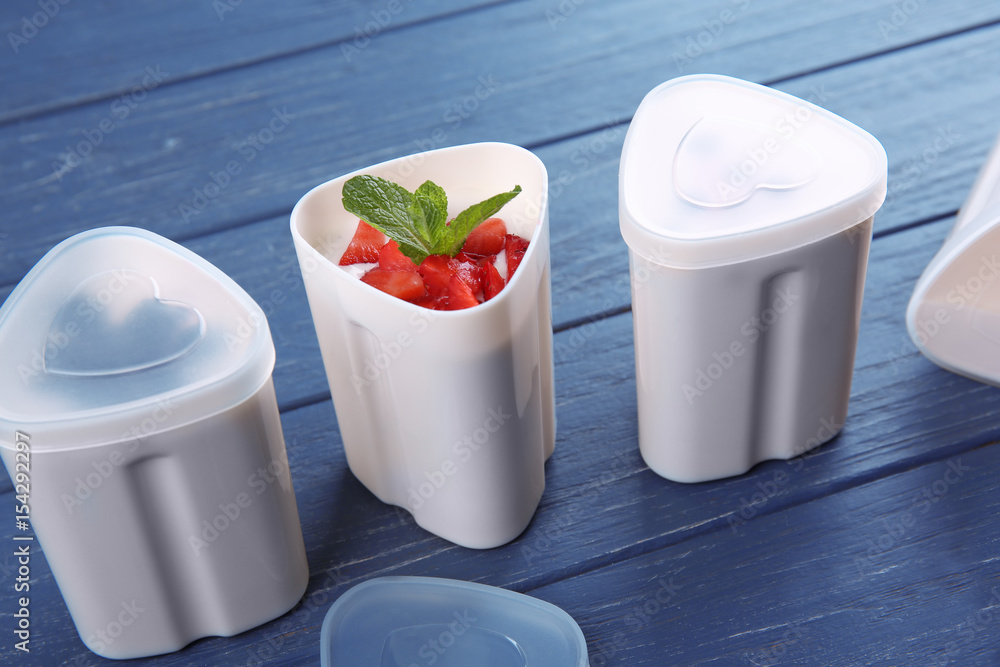 Plastic cups of yogurt maker on wooden background Plastic cups of yogurt maker on wooden background