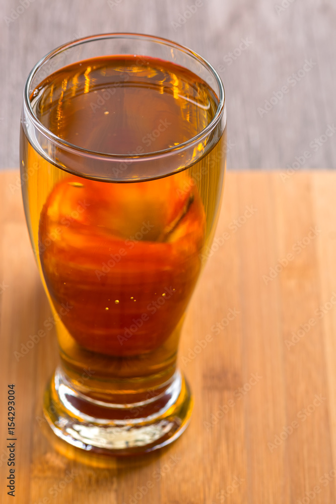 Apple juice in a glass with a red Apple Apple juice in a glass with a red Apple