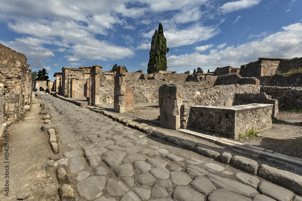 The street with remains of roman buildings in Pompeii, Italy