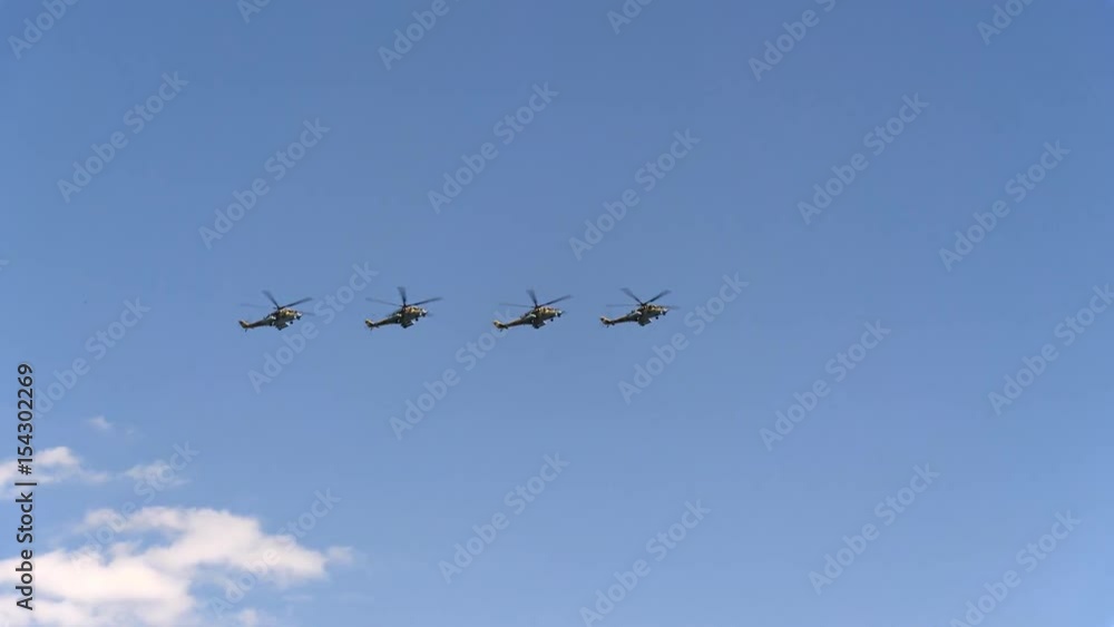 Combat helicopters Mi-24 fly in blue sky Combat helicopters Mi-24 fly in blue sky