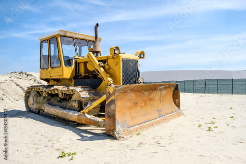 crawler caterpillar bulldozer used to push sand  on beach