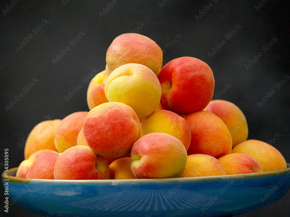 blue dish with red and yellow apricots blue dish with red and yellow apricots