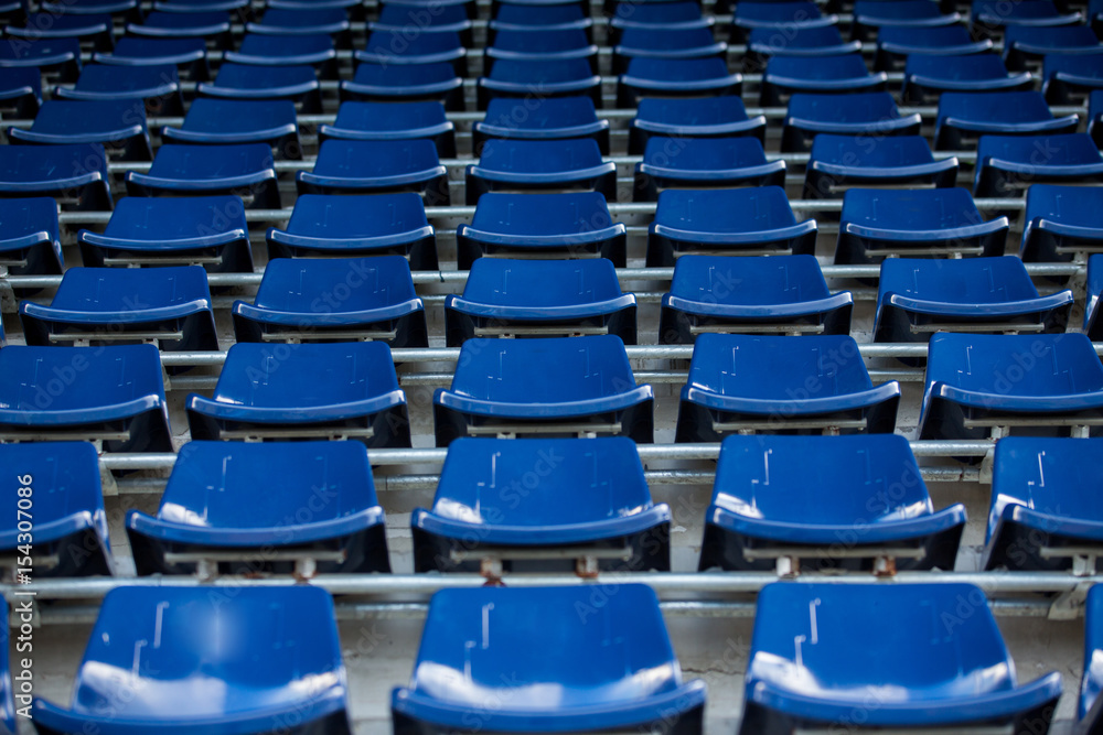 Fototapeta premium Rzędy niebieskich plastikowych krzesełek stadionowych.