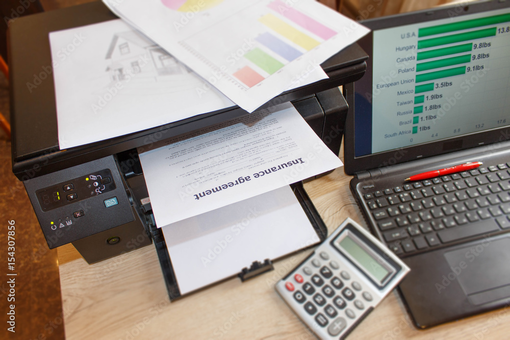 Homeowner and car Insurance form with Laptop, Printer, pen, calculator on the table Homeowner and car Insurance form with Laptop, Printer, pen, calculator on the table