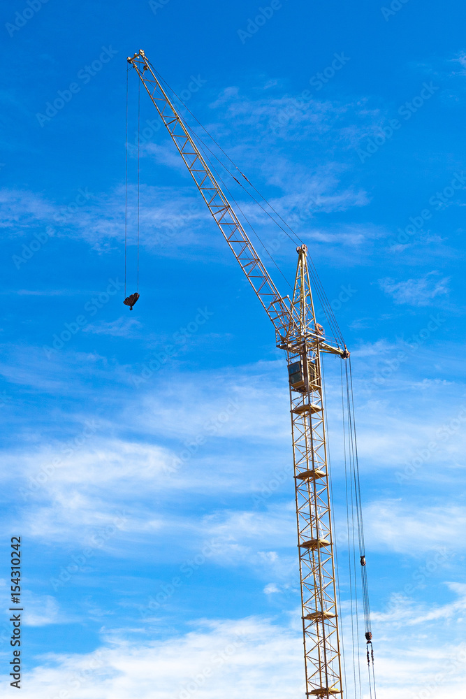 High construction crane on blue sky background High construction crane on blue sky background
