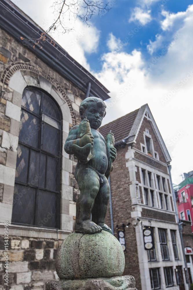 Obraz premium Bronze sculpture of a boy holding two fishes at Fischmarkt in Aachen