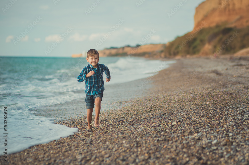 Portrait of happy boy standing alone at beach
