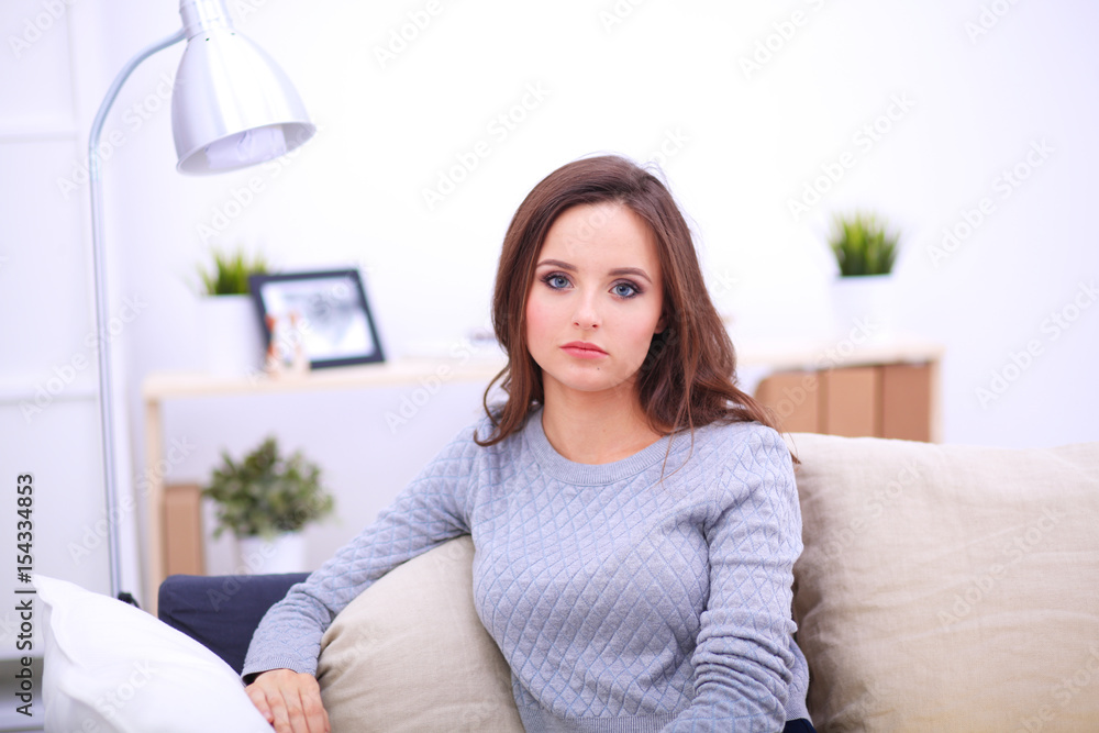 Portrait of happy young woman sitting on sofa Portrait of happy young woman sitting on sofa