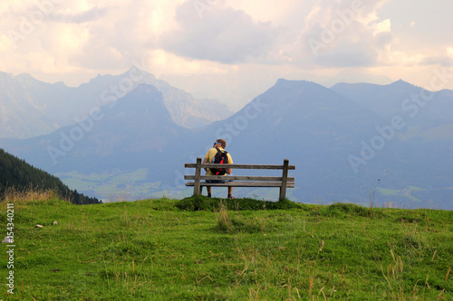 Travel to Sankt-Wolfgang, Austria. The young man are sitting on a bench with view on the mountains. © Nadezhda Zaitceva