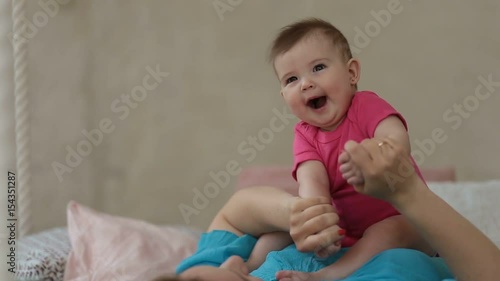 Adorable baby girl laughing in sunny bedroom
