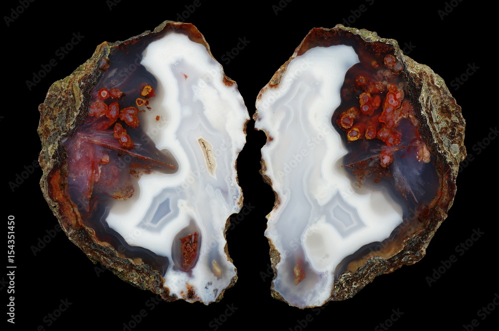 A cross section of the eyelet agate stone. Numerous pseudomorphs after dissolved minerals and multicolored silica rings colored with metal oxides are visible. Origin: Asni, Atlas Mountains, Morocco. A cross section of the eyelet agate stone. Numerous pseudomorphs after dissolved minerals and multicolored silica rings colored with metal oxides are visible. Origin: Asni, Atlas Mountains, Morocco.
