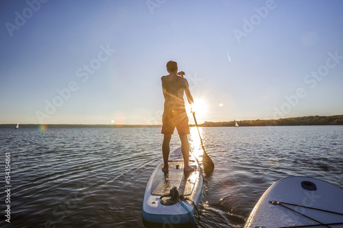 Standup paddler im Sonnenuntergang