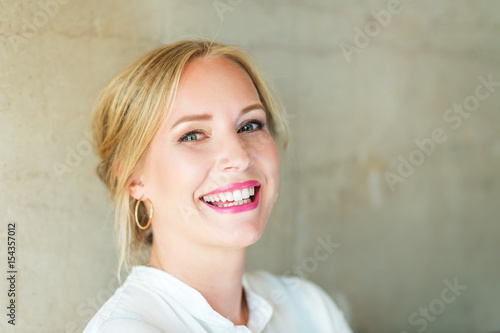 Close up portrait of beautiful blond woman with blue eyes  wearing professional makeup